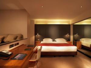 una camera d'albergo con letto e scrivania con scrivania di Royal Garden Hotel a Londra
