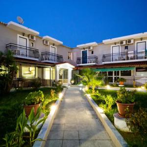 a walkway in front of a house at night at Perkes Hotel Complex in Laganas