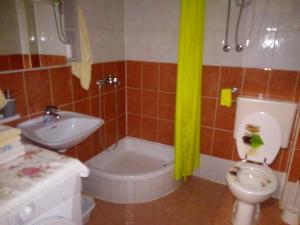 uma casa de banho com uma banheira, um WC e um lavatório. em Apartmani Ćubela em Gradac