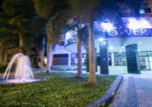 una fuente frente a un edificio por la noche en Hotel Minas Tower en Leopoldina