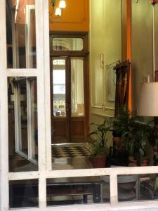 uma porta da frente de um edifício com vasos de plantas em Derby Home Hotel em Buenos Aires