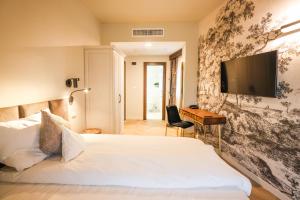 a bedroom with a bed and a desk and a television at Pensiunea Nora in Timişoara