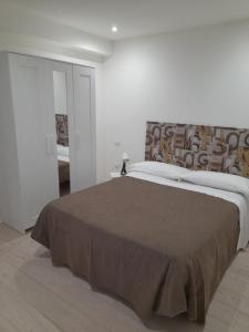 シラクーサにあるMedusa Rooms & SPAのベッドルーム1室(ブラウンの毛布を使用した大型ベッド1台付)