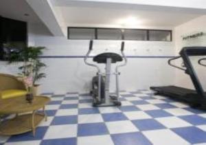 a gym with a treadmill and a checkered floor at Hotel Minas Tower in Leopoldina