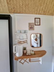 a mirror and a shelf in a tiny room at บ้านติดดิน รีสอร์ท เชียงคาน in Ban Noi