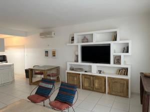 a living room with a tv and a table and chairs at Keur RAMYBĖ in Sali Nianiaral