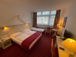 um quarto de hotel com uma cama grande e uma janela em Hotel Chateau Kurfürstendamm em Berlim
