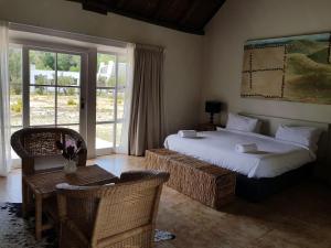 a bedroom with two beds and a table and chairs at Karoo 1 Hotel Village in De Doorns