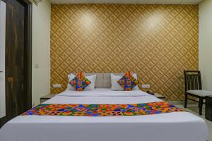 een slaapkamer met een groot bed met een muur bij FabHotel Heaven Agya Ludhiana in Ludhiana