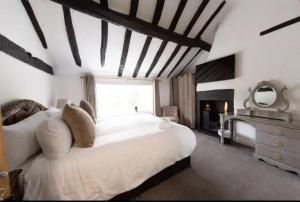 um quarto com uma grande cama branca e uma lareira em Bert's Rooms at The Black Horse Inn em Brighouse