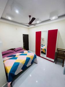 a bedroom with a colorful bed and red cabinets at Castle Villa in Ernakulam