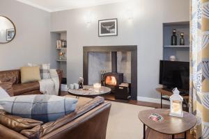 a living room with a couch and a fireplace at Rose Cottage - Seasgair Lodges in Carrbridge