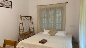 a bedroom with a bed and a ladder and a window at Tattwamasi Ayuryoga with Breakfast and Yoga in Varkala