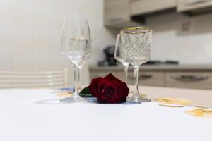 eine rote Rose und zwei Weingläser auf dem Tisch in der Unterkunft Diana Home in Fiumicino