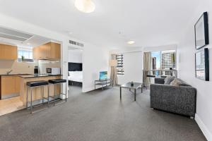 a living room with a couch and a kitchen at AirCabin - Sydney CBD - Best Location -1 Bed Apt in Sydney