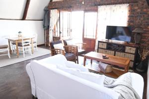 salon z białą kanapą i telewizorem w obiekcie Bonnie View Game Lodge w mieście Hilton