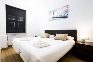 a bedroom with two beds with white sheets at Bakea by Smiling Rentals in Hondarribia