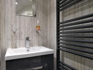 bagno con lavandino bianco e specchio di Brooklands Guest House a Bowness-on-Windermere