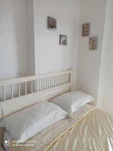 菲烏米奇諾的住宿－Fiera&Aeroporto House，卧室内的一张床铺,墙上有两张照片