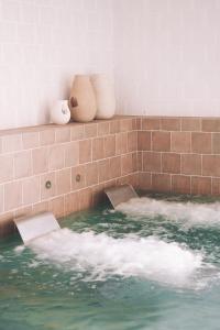 a bath tub filled with water next to a brick wall at Santa Brigida - Real 1 in Hontanas