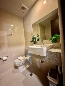 a bathroom with a sink and a toilet and a mirror at BGC, Uptown Parksuites Tower 2 in Manila