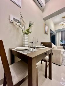 a dining room table with a vase of flowers on it at BGC, Uptown Parksuites Tower 2 in Manila