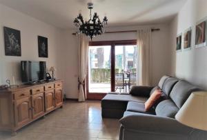 a living room with a couch and a tv at Apartamento Country Club 605 in Pals