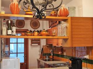 a kitchen with wooden shelves with bottles and glasses at Apartamento Country Club 605 in Pals