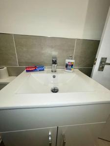 a white bathroom sink with a toothbrush and toothpaste at Huntingdon Luxury Apartments in Huntingdon
