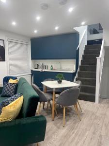 a living room with a couch and a table and stairs at Huntingdon Luxury Apartments in Huntingdon