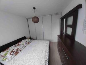 1 dormitorio con cama y tocador de madera en Lovely apartment - Žilina centrum en Žilina