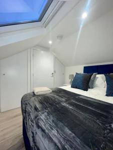 a bedroom with a large bed and a skylight at Huntingdon Luxury Apartments in Huntingdon