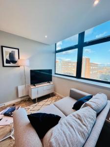 uma sala de estar com um sofá e uma televisão de ecrã plano em Spectacular Studio Apartment near to Old Trafford stadium em Manchester