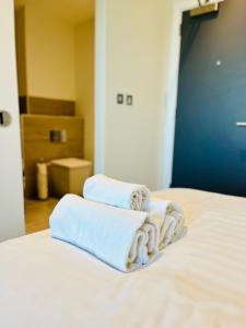 sterta ręczników na łóżku w obiekcie Spectacular Studio Apartment near to Old Trafford stadium w Manchesterze