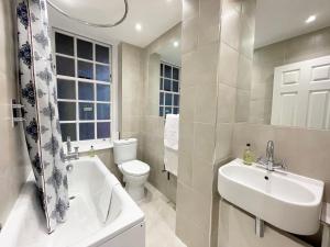 a bathroom with a sink and a toilet and a tub at Westminster Apartment near River Thames in London