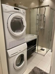 eine Waschmaschine und einen Trockner im Bad mit Dusche in der Unterkunft Eiganesveien 1 in Stavanger