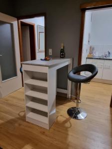 a white desk with a black chair in a room at Meerblick in Glücksburg