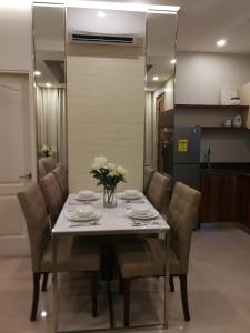 a dining room table with chairs and a vase of flowers at Adria Residences - Sapphire Garden - 2 Bedroom for 4 person in Manila