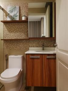 a bathroom with a toilet and a sink and a mirror at Adria Residences - Sapphire Garden - 2 Bedroom for 4 person in Manila