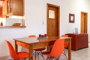 a kitchen with a wooden table and orange chairs at Creta 2 bedrooms 6 persons village house in Vasilópoulon