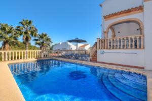 a swimming pool in front of a house at Monte Azul in Jávea