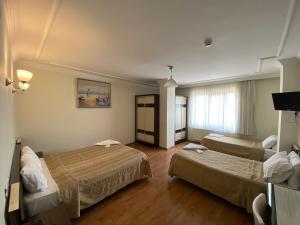 a hotel room with two beds and a window at OTEL KING in Isparta