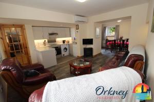 uma sala de estar com um sofá e cadeiras e uma cozinha em 89 Victoria Street, Kirkwall, Orkney - OR00066F em Orkney