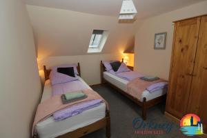 a bedroom with two beds in a room with a window at 89 Victoria Street, Kirkwall, Orkney - OR00066F in Orkney