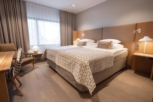 Una habitación de hotel con una cama grande y un escritorio. en Original Sokos Hotel Lakeus Seinäjoki, en Seinäjoki
