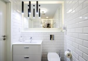 a white bathroom with a sink and a mirror at Apartament Old Town Gdańsk Tartaczna 16D in Gdańsk