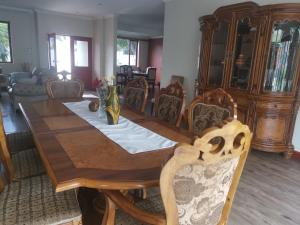 Falklands Guest House في جوهانسبرغ: طاولة طعام خشبية مع كراسي وغرفة طعام