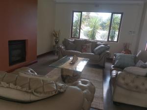 Sala de estar con sofás y mesa de centro en Falklands Guest House, en Johannesburgo