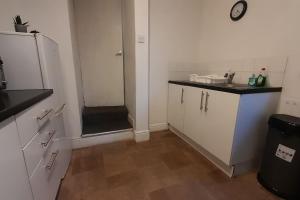 a small kitchen with a sink and a refrigerator at Spacious 4 Bedroom, Free Netflix, Central Location in Cardiff