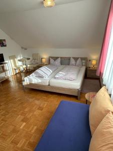 a bedroom with a bed and a living room at Restaurant - Pension Herrgottstal in Creglingen